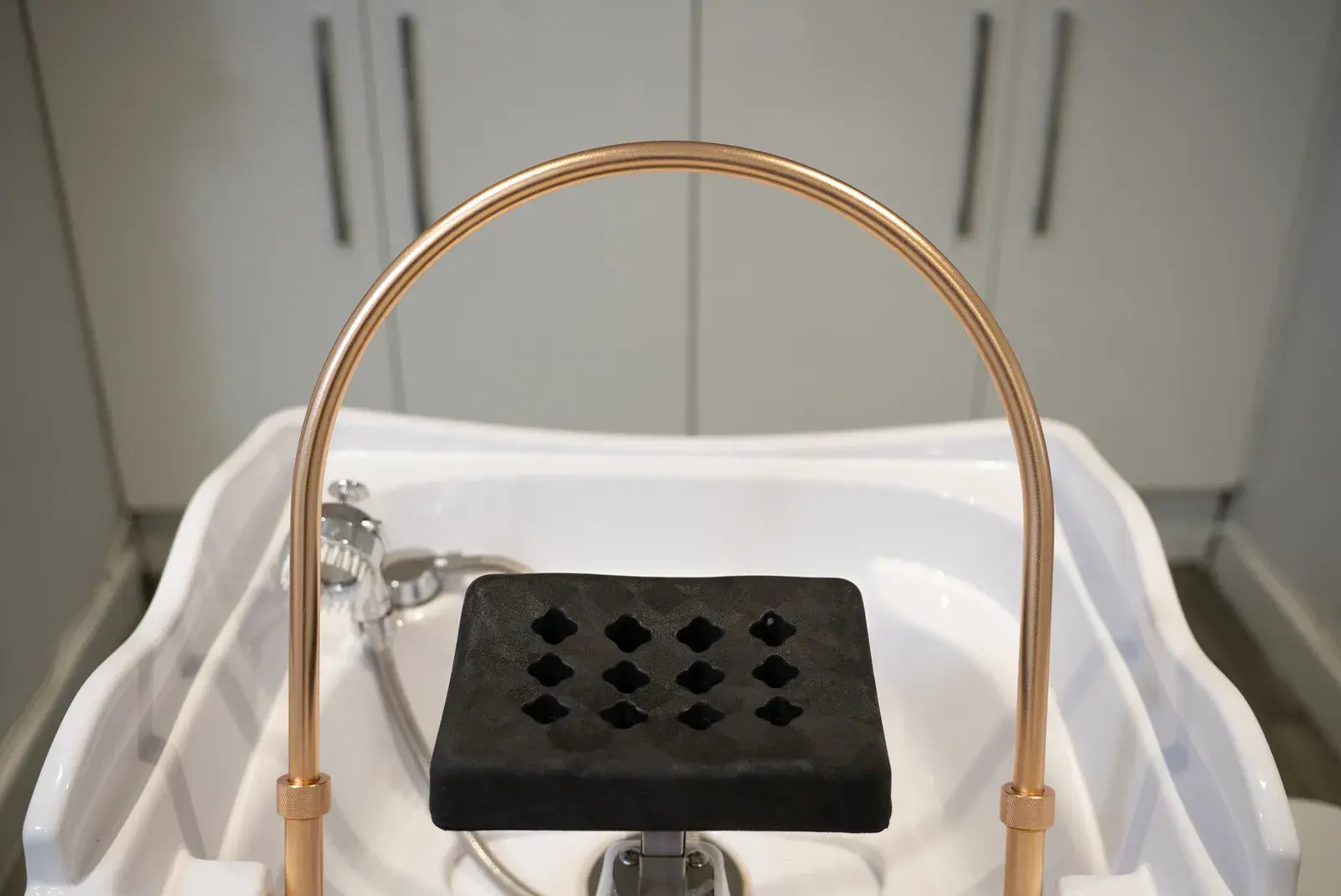 The head spa basin with its curved shower arch and headrest