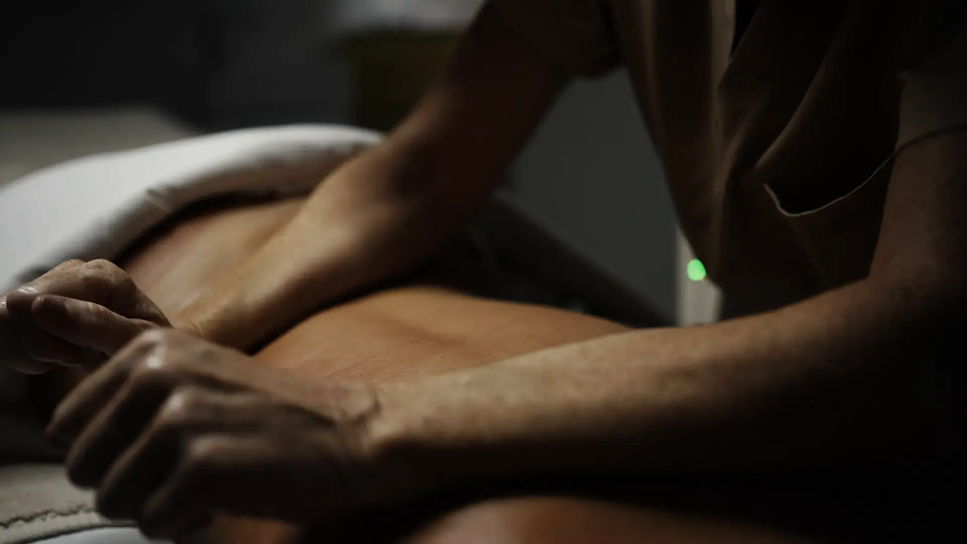 A practitioner's hands work along a client's back during a massage